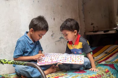 Two young boys studying at home during covid lockdown, India.