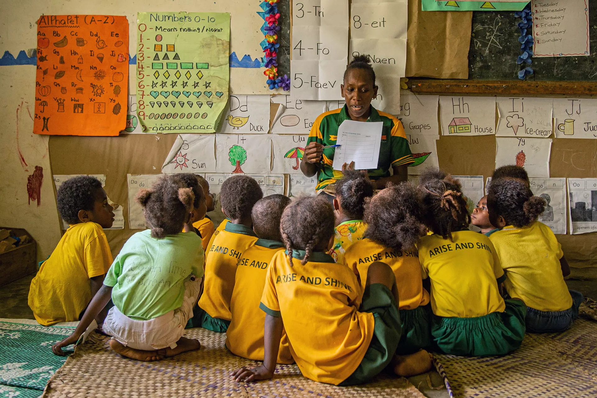 A teacher reading to her students in a mainstream classroom during a group activity, Vanuatu