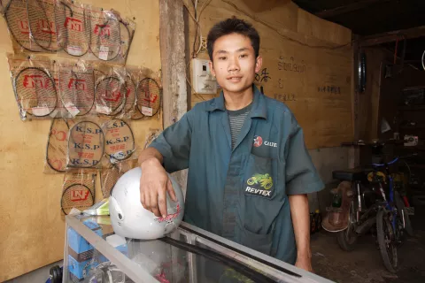 A young man in his small motor bike repair workshop, Laos